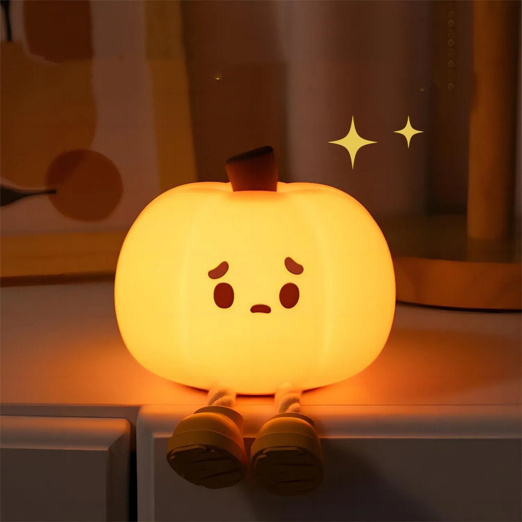Pumpkin night light sitting on a shelf at night with its legs dangling